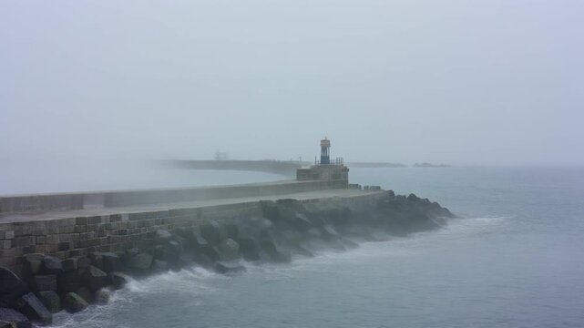 Sea fog rolling over a breakwater