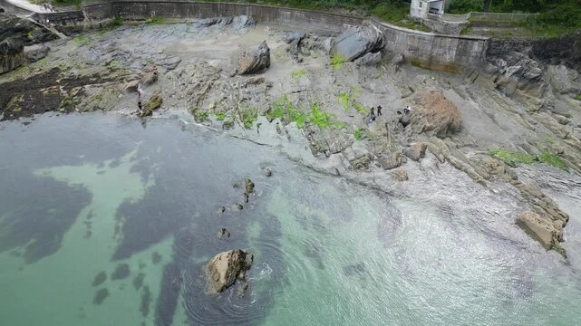 High Angle Footage of Beach and Ocean at Looe Town of England During Hot Sunny Day. Looe is a coastal town and civil parish in southeast Cornwall, England, United Kingdom.