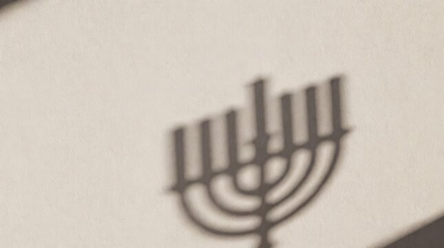 Menorah Shadow on Textured Beige Wall