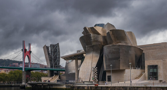 Bilbao, Pa&iacute;s Vasco, Espa&ntilde;a. 1 de Septiembre 2026. Vista del ic&oacute;nico Museo Guggenheim Bilbao dise&ntilde;ado por Frank Gehry y el puente de La Salve bajo un cielo nublado y dram&aacute;tico.