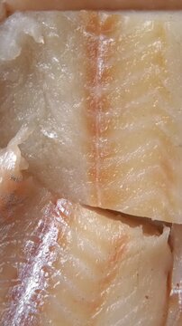 Raw fish fillet is spinning. Top view. Slices of fresh whitefish. Full frame. Sashimi rotation. Marine market. Vertical Video for sale. Cod, pollock loin steaks. Pangasius, tilapia pieces background