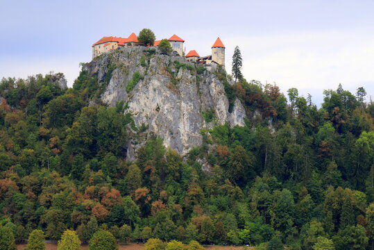 Lake Bled, Slovenia: Beautiful view of the old castle on a high rock near the lake. Beautiful blue mountains