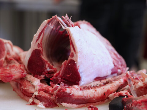 Morceau de viande d'agneau pr&eacute;par&eacute;e en carr&eacute; d'agneau o&ugrave; on voit les cotes et les morceaux d'os.