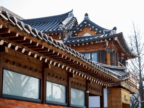 View of Bukchon Hanok Village featuring traditional Korean architecture with intricate wooden beams and dark tiled roofs in Seoul, Seoul, South Korea.