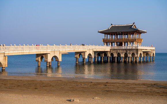 View of the Iga-ri Anchor Observatory, a traditional pavilion on a pier extending into the sea with a sandy beach in the foreground in Pohang-si, Gyeongsangbuk-do, South Korea.