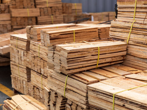 View of stacked wooden planks secured with yellow plastic straps in a storage yard in Busan, Busan, South Korea.