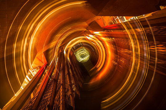 View of circular light trails created by long exposure photography within the modern architectural stairwell at Edith Cowan University in Joondalup, Western Australia, Australia.