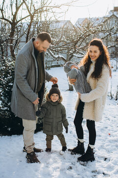 Family of four enjoying winter day in snowy garden