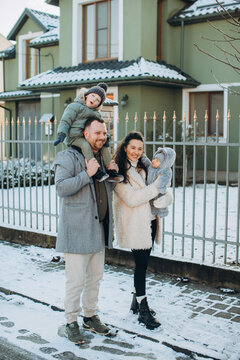 Happy family enjoying winter day outdoors with children