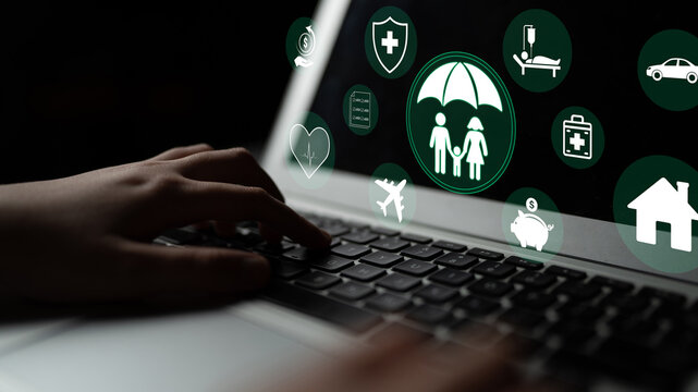 Conceptual Image of Digital Insurance Services with Family Protection Icons and Hand on Laptop Keyboard in a Dark Environment Haptic.