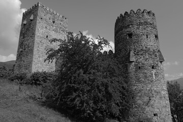 Anciennes tours défensives en pierre d'une forteresse médiévale en Géorgie avec végétation et paysage montagneux © Cyril.Labourayre