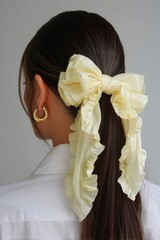 Elegant hairstyle with large yellow bow accessory.