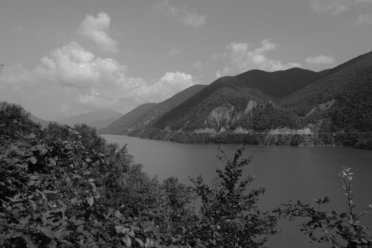Lac de montagne en G&eacute;orgie avec versants bois&eacute;s, collines et v&eacute;g&eacute;tation au premier plan