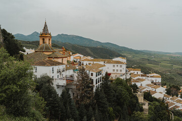 Aerial view of white village rooftops and church tower on a cliffside in Spain © Puripat