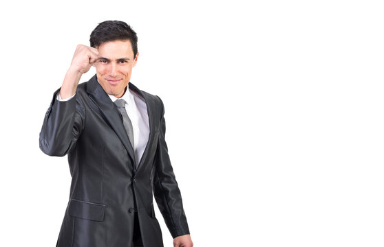 Self assured young male with dark hair in formal suit and tie showing fist and smiling at camera