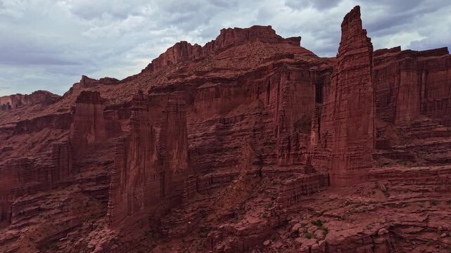 Dramatic aerial perspectives reveal towering mudstone spires and rugged fins below moody evening skies at Fisher Towers near Moab Utah