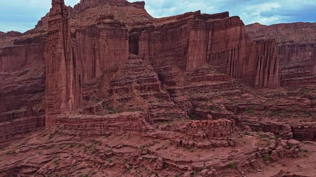 Dramatic aerial perspectives reveal towering mudstone spires and rugged fins below moody evening skies at Fisher Towers near Moab Utah
