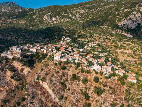 Drone view of small Albanian village built on rocky hillside, real Mediterranean landscape and rural lifestyle illustration in QEPARO FUSHE, ALBANIA