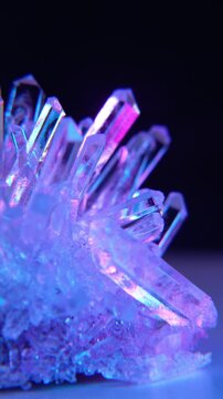 A mysterious, magical, genuine crystal. The grown crystal rotates on an illuminated turntable. A scientific experiment and chemical study. A beautiful background or screensaver. Blue and pink.
