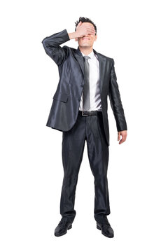 Full body of content male entrepreneur in suit covering eyes while standing on transparent background