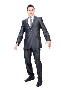Full length of astonished young male manager with dark hair in elegant suit looking at camera after unexpected news