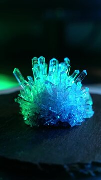 A mysterious, magical, genuine crystal. The grown crystal rotates on a turntable illuminated by full-spectrum RGB lighting. A scientific experiment and chemical study. A beautiful background