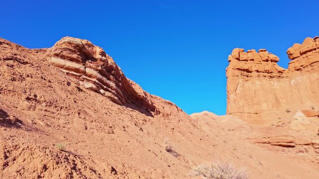 Morning sunlight illuminates unique sandstone goblins and weathered rock formations along the Basilisk Trail in Goblin Valley State Park Utah