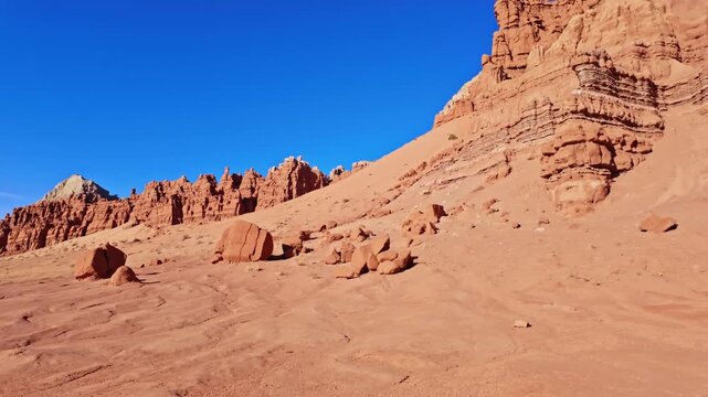 Morning sunlight illuminates unique sandstone goblins and weathered rock formations along the Basilisk Trail in Goblin Valley State Park Utah