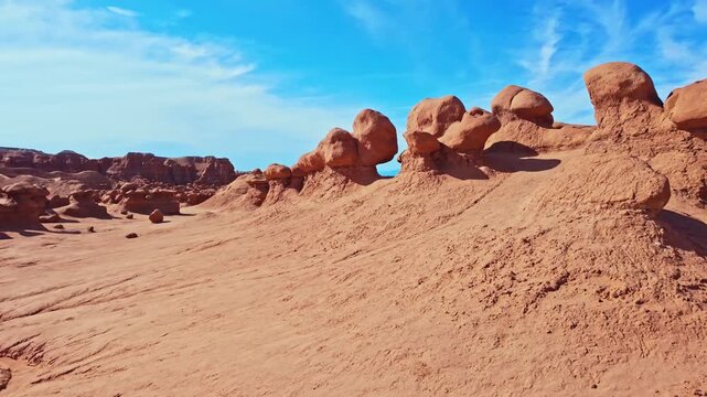 Unique mushroom-shaped sandstone hoodoos stand across the rugged desert badlands of Goblin Valley State Park in Utah