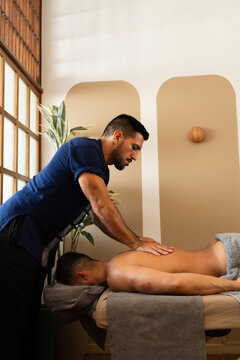 Massage Therapist Performing Professional Back Massage Treatment