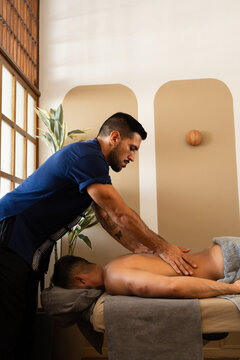 Massage Therapist Performing Professional Back Massage Treatment