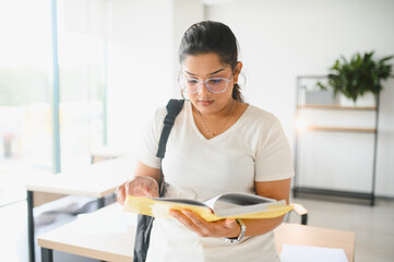 Indian female student intently studying school book