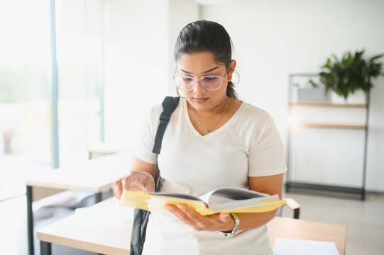 Indian female student intently studying school book