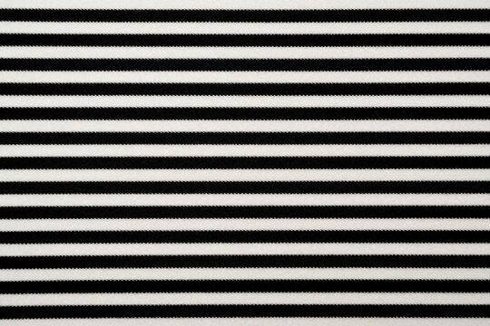 Black and white horizontal striped fabric texture background, repeating linear pattern on textile material. Simple graphic design, modern fashion, wallpaper element.