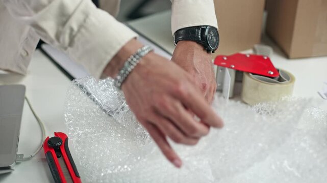 Hands gently press bubble wrap over a package