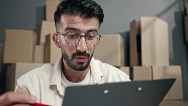 Young man with glasses focuses on tablet