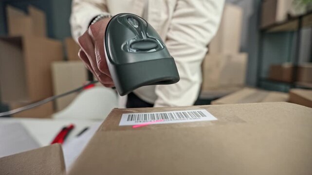 Hand scans barcode on cardboard package
