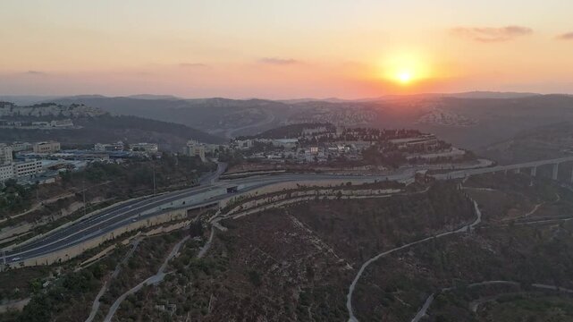 A time-lapse shot of traffic in Jerusalem, featuring high-rise buildings.