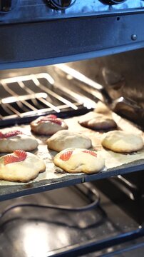 Vertical video of an open oven with homemade strawberry cookies that didn't quite turn out, an authentic, imperfect baking fail