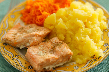 Tradycyjny obiad domowy: pieczony filet z łososia (Salmo salar), gniecione ziemniaki oraz surówka z tartej marchewki. Zdrowy posiłek pełen kwasów omega-3 i witamin, idealny do menu. © Henryk Niestrój