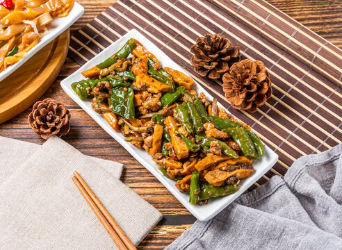 Hakka style stir fried pork with dried squid and green peppers served on a white rectangular plate