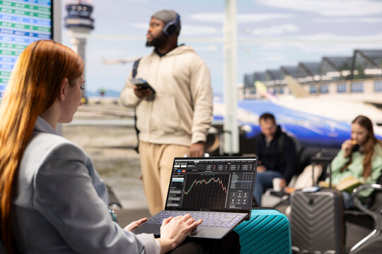 Woman reviews stock charts and hedge fund performance at airport