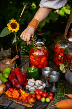 Canning tomatoes procedure using seaming key (seaming maching) and metal SKO lid. Home food preservation in glass jars. Rustic design.