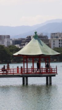 Ohori Park panorama in Fukuoka, Japan, Chuo-ku ward, Kyushu island, with pond, Ukimi-do pavilion, bridges and city skyline near Maizuru Park, lake and promenade in a spring sunny day