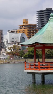 Ohori Park panorama in Fukuoka, Japan, Chuo-ku ward, Kyushu island, with pond, Ukimi-do pavilion, bridges and city skyline near Maizuru Park, lake and promenade in a spring sunny day