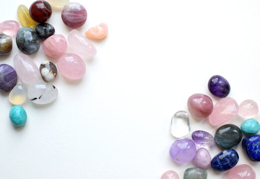 Natural amethyst, rose quartz, and agate crystals on a white background. Stone frame. Healing crystals. Divination and magic.