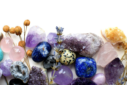 Natural amethyst, citrine, and schorl (black tourmaline) crystals, as well as dried herbs. Stone frame. Healing crystals. Copy space.