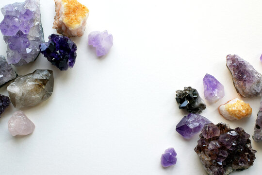Natural amethyst, citrine, and smoky quartz crystals on a white background. A frame made of stones. Healing crystals. Divination and magic.