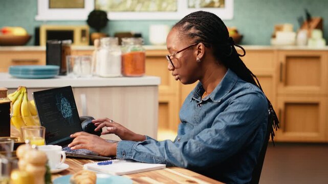 Self-employed woman telecommutes with generative artificial intelligence, focused on analytics and task management on laptop. Deep learning systems support data processing on screen at home.