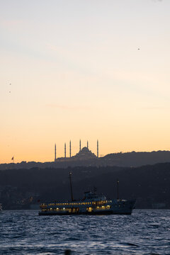 Ferry crossing the Bosphorus at sunset below Camlica Mosque, vertical